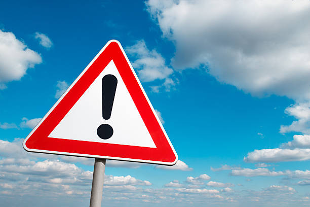 Warning sign Warning road sign against a cloudy sky. road warning sign photos stock pictures, royalty-free photos & images