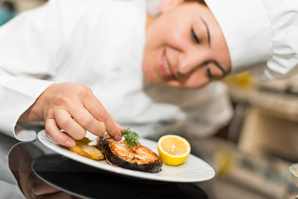 istock Professional chef places finishing touches on meal 480655276