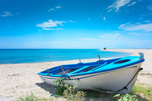Blue boat against coastline landscape.