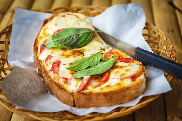 Italian bruschetta with tomatoes, basil and cheese on grilled crusty bread