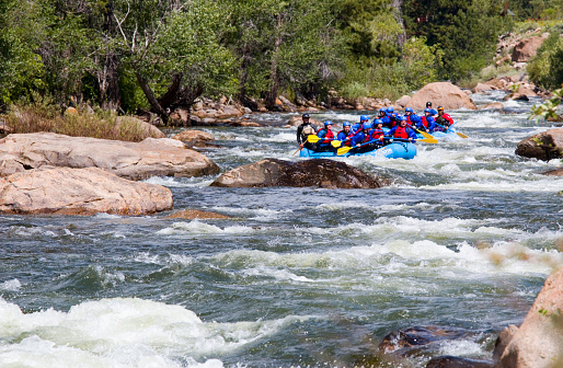 Buena Vista, Colorado, USA - July 11, 2015: People enjoying whitewater sports, including whitewater rafting and kayaking on the roiling whitewater of the Numbers Rapids on the Arkansas River near Highway 24 in Buena Vista Colorado