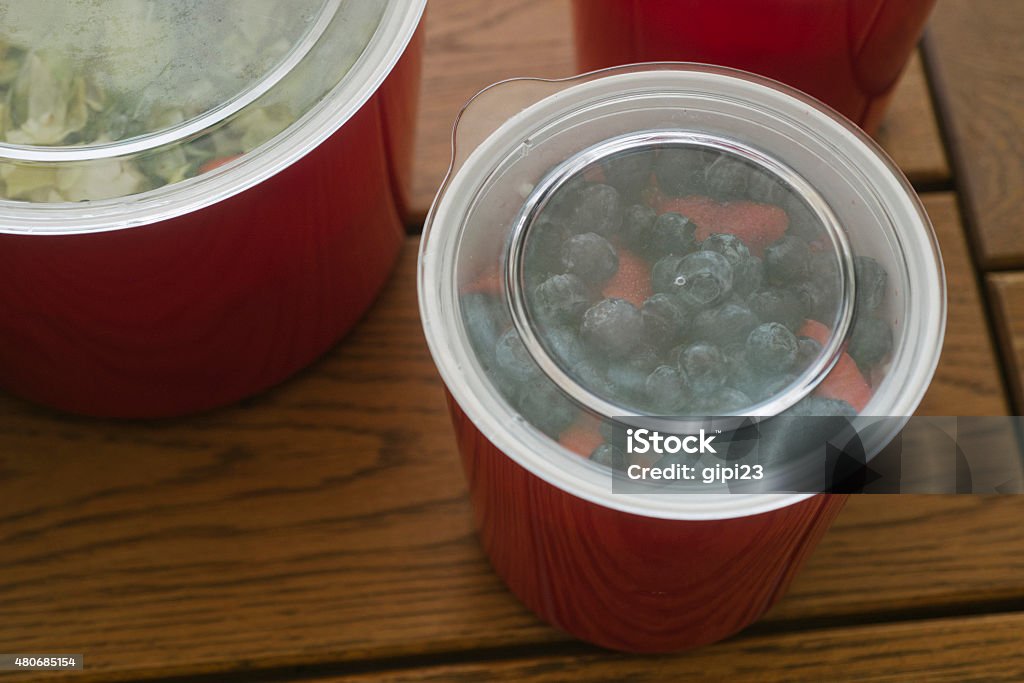 Freshly picked blueberries and strawberries kept in a container Freshly picked blueberries and strawberries kept in a container, covered with plastic transparent lids, next to a container with organic salad. 2015 Stock Photo