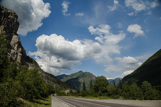 road in mountains on the background of clouds
