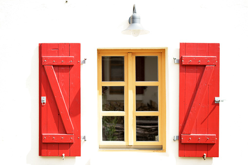 Bright red colored shutters on a nostalgic window.
