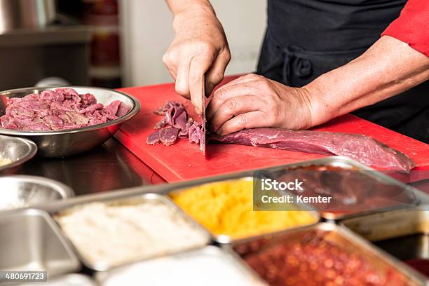 Cook Cutting Meat In Kitchen Stock Photo - Download Image Now - Adult, Adults Only, Apron