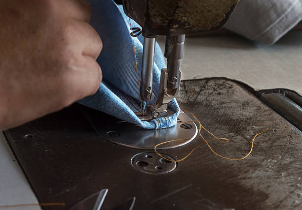 istock Woman hands sewn fabric repairs on sewing machine 480692164