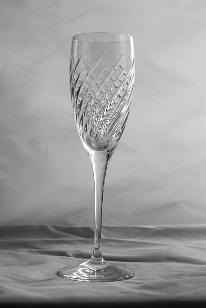 Crystal cut drinking glass on grey background with folded material Crystal cut drinking glass on grey background with folded material lead cut glass crystal stemware stock pictures, royalty-free photos & images