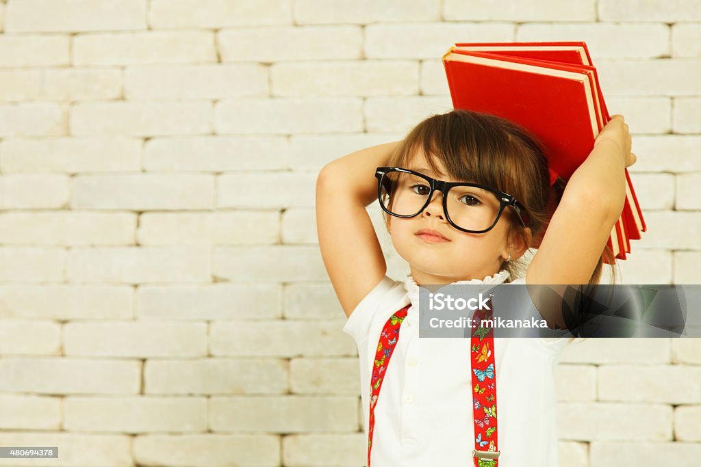 Preschooler girl with books Preschooler girl with books on the head Back to School Stock Photo