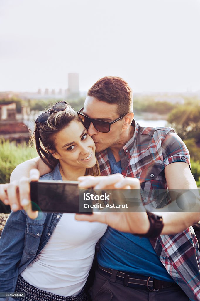 Happy couple taking selfies Young happy couple taking selfies 2015 Stock Photo