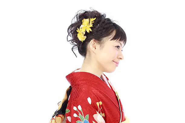Beautiful young woman dressed in traditional Japanese Kimono, isolated on white background.