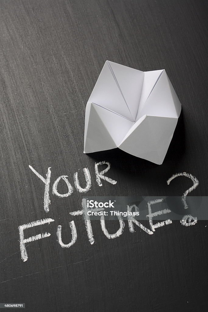 Your Future Concept Origami Fortune Teller made from white paper on a blackboard next to the question Your Future? written by hand in chalk Origami Fortune Teller Stock Photo