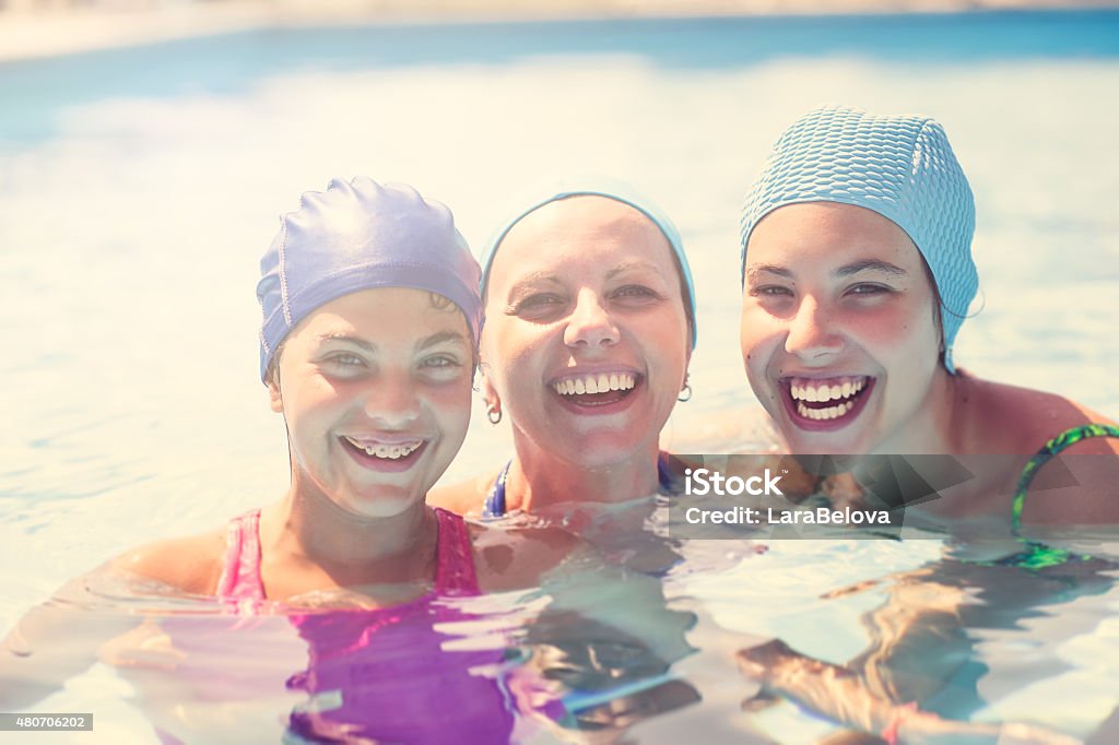 Real mother with her daugnters in swimming pool Real mother with her daugnters in swimming pool, outdoors. 2015 Stock Photo