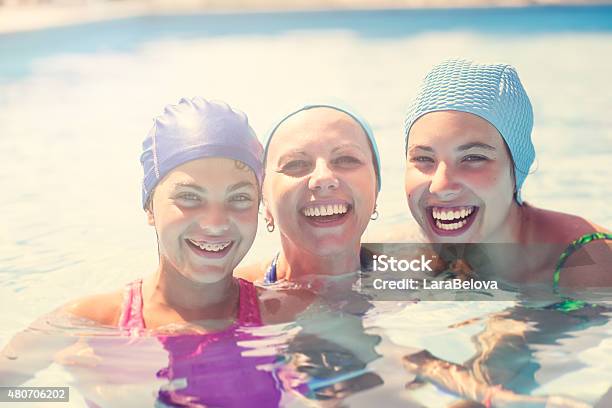 Real Mother With Her Daugnters In Swimming Pool Stock Photo - Download Image Now - 2015, Adult, Cheerful