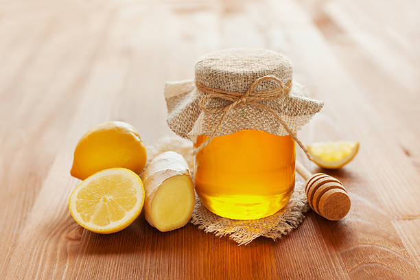 istock honey in jar with twine, honey dipper, lemon and ginger 480708922