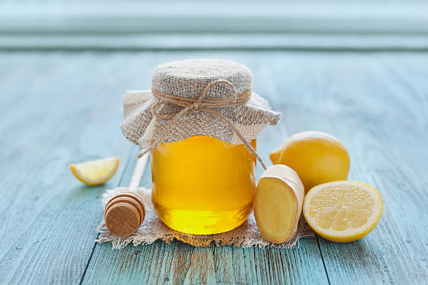 istock honey in jar with twine, honey dipper, lemon and ginger 480708924