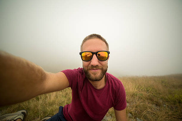 istock Young man on mountain trail taking selfie 480709464