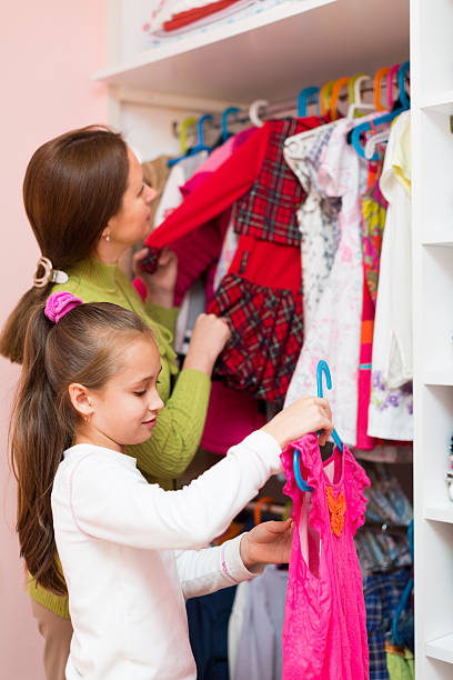 istock mam teaching girl to choose clothes 480710122