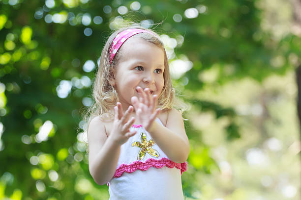 chica rubia sonriente niño de las palmas con su palms - child dancing preschooler outdoors fotografías e imágenes de stock