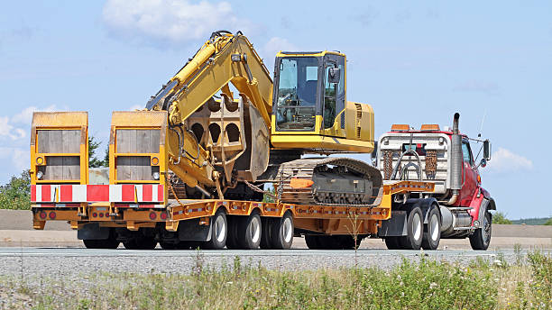 yellow truck carrying excavator