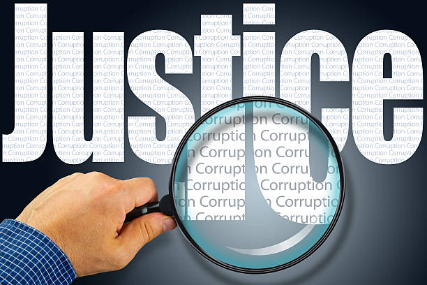 istock JUSTICE - CORRUPTION Opposite message, Hand holding magnifying g 480718878