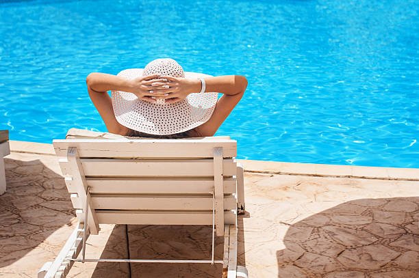 istock Woman in white hat lying on a lounger 480719412