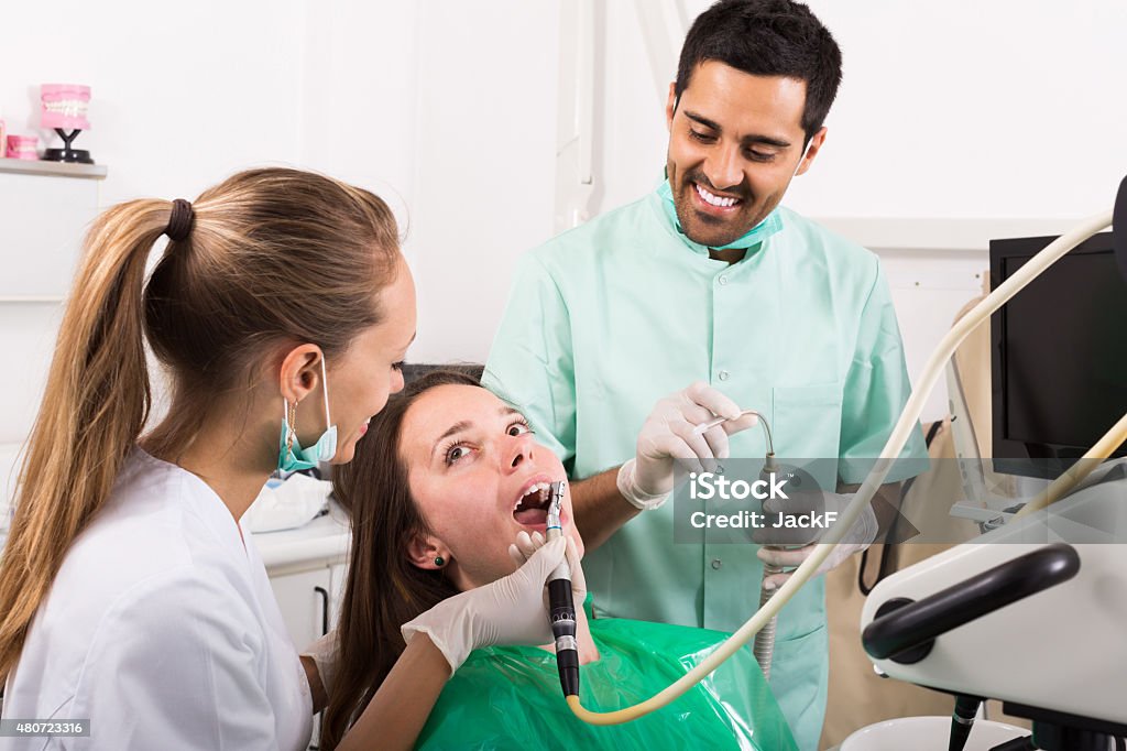 patient checking out her teeth at dentist Sad adult patient checking out her teeth at dentist 2015 Stock Photo