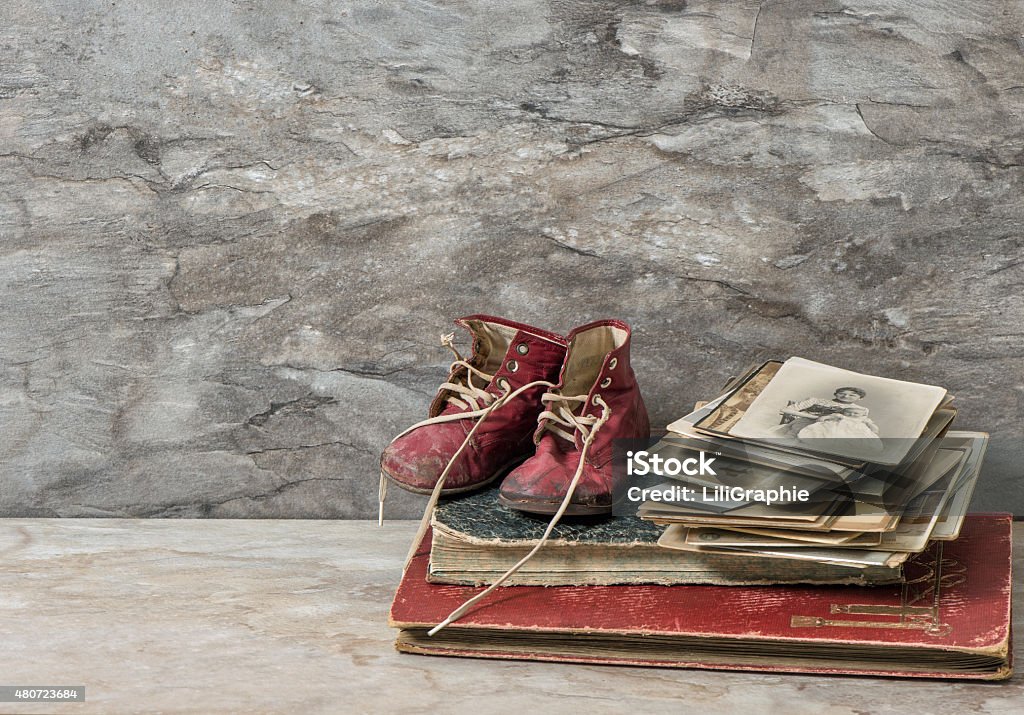 Antique books, photos, and baby shoes. Nostalgic still life - Royaltyfri 2015 Bildbanksbilder