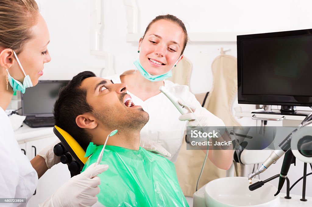 Patient checking the teeth Young man patient checking the teeth on computer equipment 2015 Stock Photo