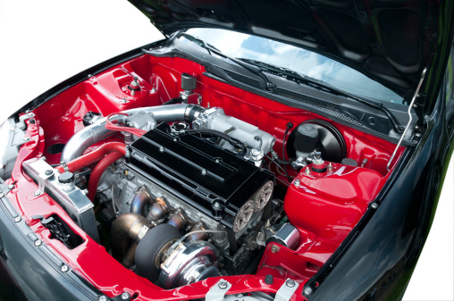 A compact car's clean engine compartment with all logos removed.