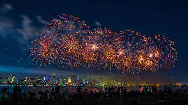 Crowd Watching Fireworks Display Over the River stock photo