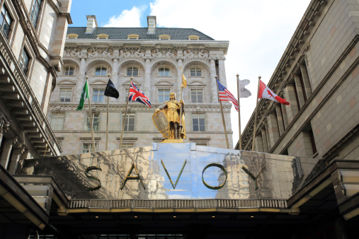 London, United Kingdom - March 17, 2014: Savoy Hotel view from the Strand in the City of Westminster in central London with the Savoy Peter statue on top of the entrance. Originally opened in 1889, this London legend closed in 2007. It re-opened in 2010 under the management of Fairmont Hotels and Resorts.
