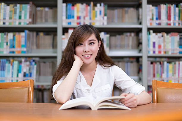 istock Beautiful asian female student read book in library 480736534