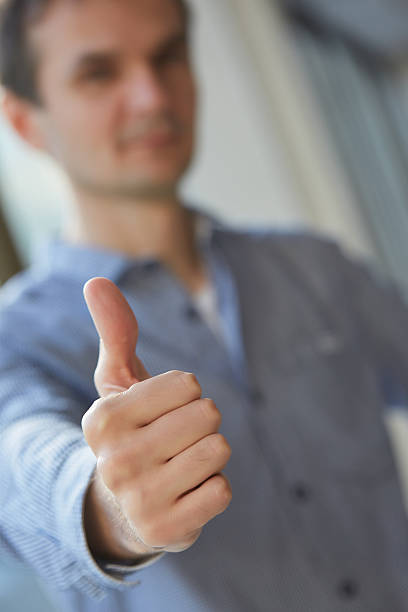 istock man in shirt shows thumb closeup 480738116