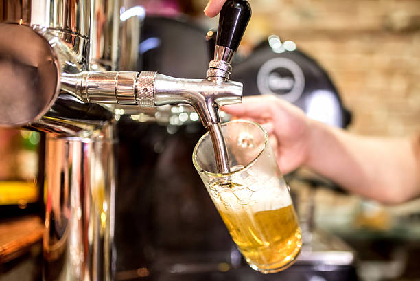 istock barman hand at beer tap pouring draught lager beer 480739028