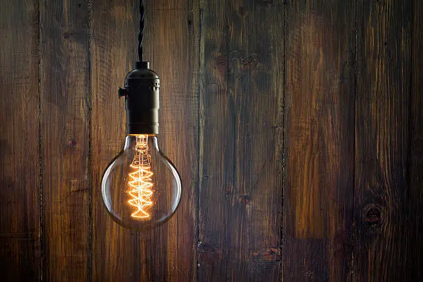 Photo of Vintage incandescent Edison type bulb on wooden background