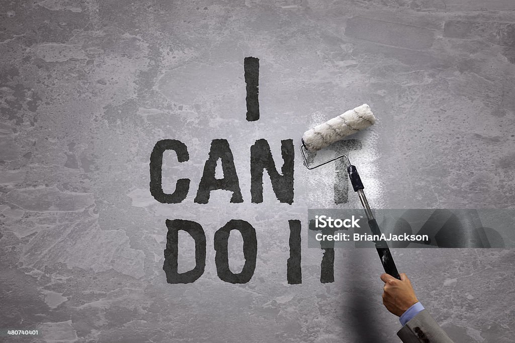 I can do it Changing the word can't to can by painting over and erasing part of it with a paint roller on a concrete wall in the phrase i can do it Covering Stock Photo