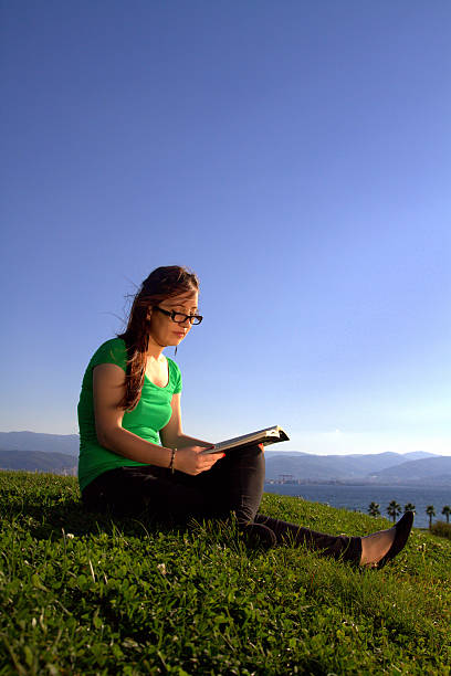 istock Woman is reading a book on the grass 480744315