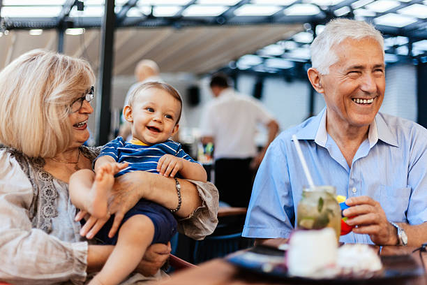 Grandparents With Their Grandson Spending Lovely Time At Cafe