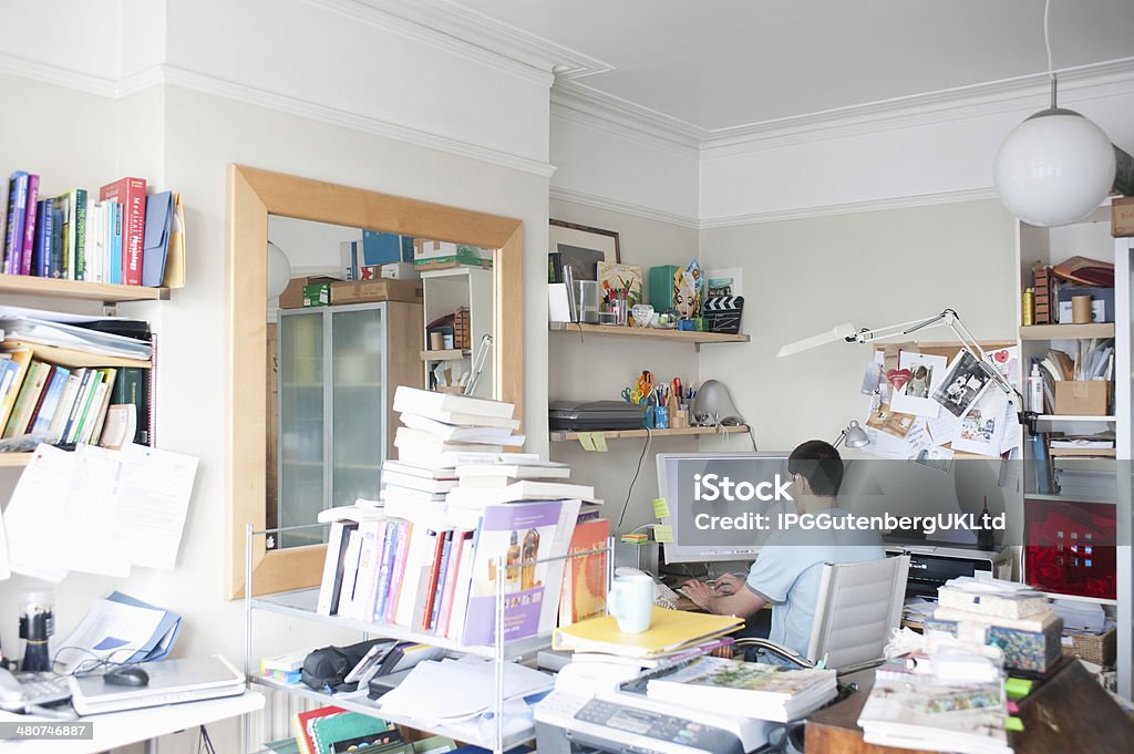 Hombre de negocios usando el ordenador en su oficina - Foto de stock de Desordenado libre de derechos