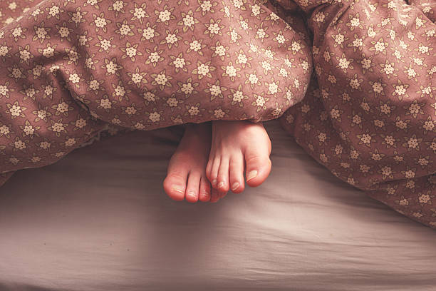 istock Woman's feet in bed 480751351