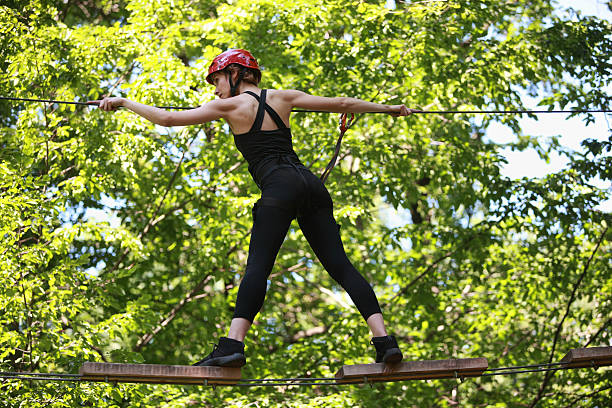 istock Young woman climbing in adventure rope park 480753063