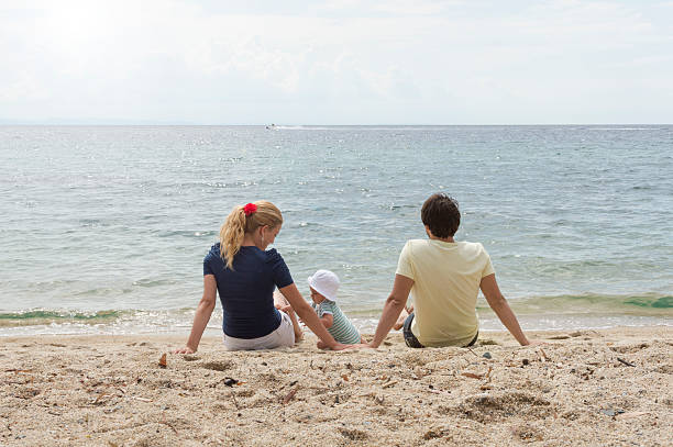 istock Happy family of three on beach vacation 480755178