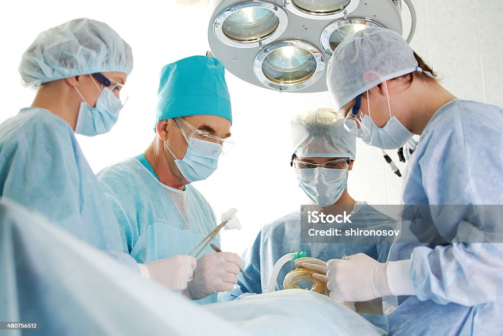 Surgeons at work Several surgeons surrounding patient on operation table during their work   Note to inspector: the image is pre-Sept 1 2009 2015 Stock Photo