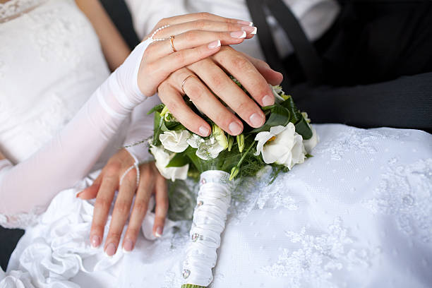 istock hands with wedding rings over the bouquet 480757687