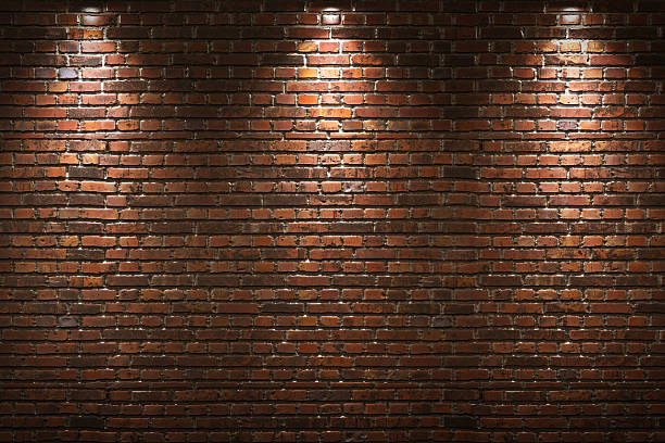 iluminado pared de ladrillos - brick fotografías e imágenes de stock