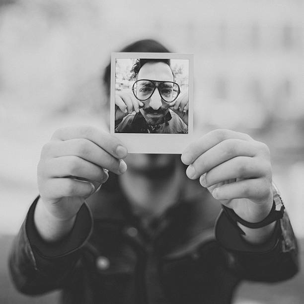 istock Man holding instant photo 480760398