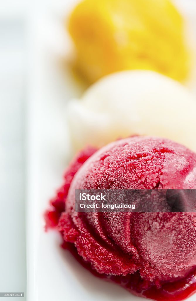 Ice-cream Scoops of ice-cream melts on a white plate, shallow DOF Backgrounds Stock Photo