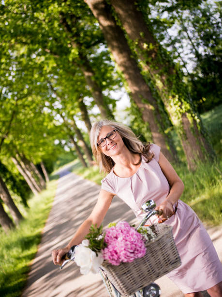istock Woman standing with her classic bicycle in a park 480760656