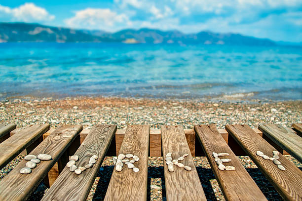 word Turkey lined with small pebbles on wooden sunbed with beautiful Aegean sea and mountains at background, Marmaris, Turkey