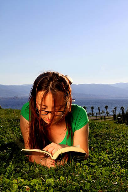 istock Woman is reading a book on the grass 480762193